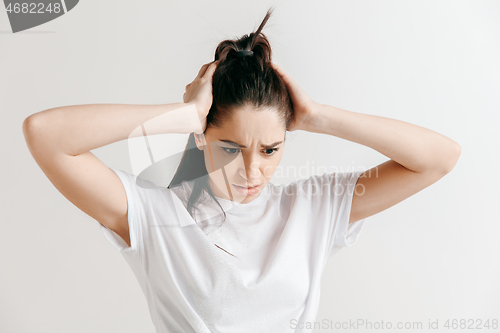 Image of Woman having headache. Isolated over gray background.