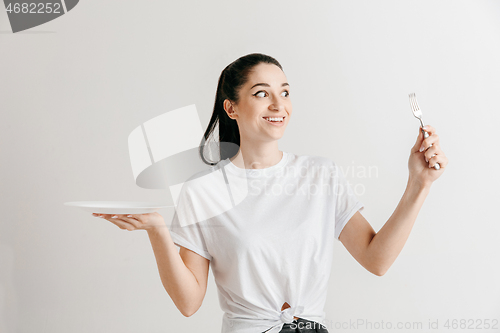 Image of Young fun crazy brunette housewife with fork isolated on white background