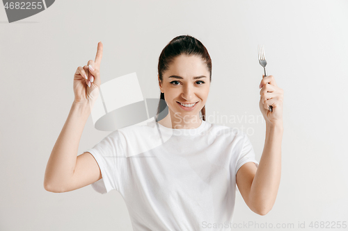 Image of Young fun crazy brunette housewife with fork isolated on white background