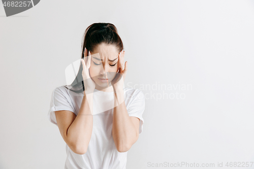 Image of Woman having headache. Isolated over gray background.