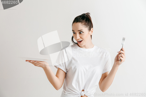 Image of Young fun crazy brunette housewife with fork isolated on white background