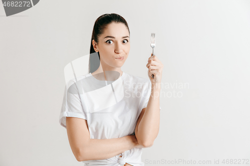 Image of Young fun crazy brunette housewife with fork isolated on white background