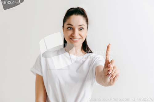 Image of Woman\'s hand with finger on gray background