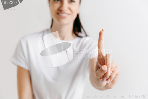 Image of Woman\'s hand with finger on gray background