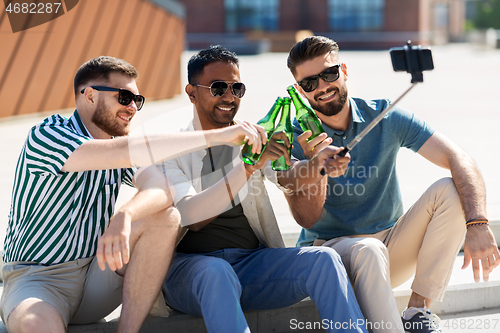 Image of men toasting beer and taking selfie by smartphone