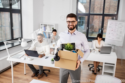 Image of happy male office worker with personal stuff