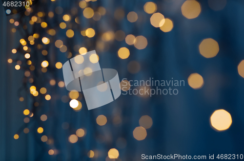 Image of christmas garland lights over dark blue background