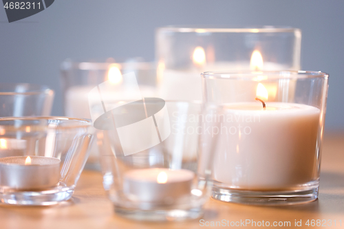 Image of burning white fragrance candles on wooden table