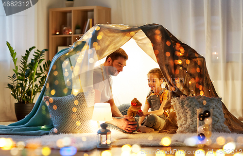 Image of happy family playing with toy in kids tent at home