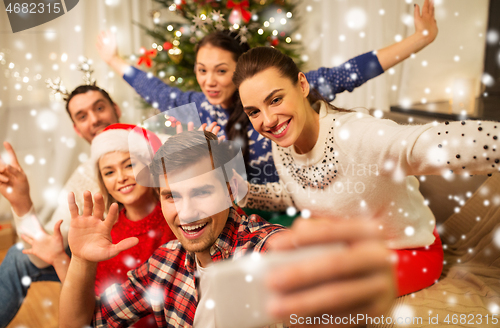 Image of friends celebrating christmas and taking selfie