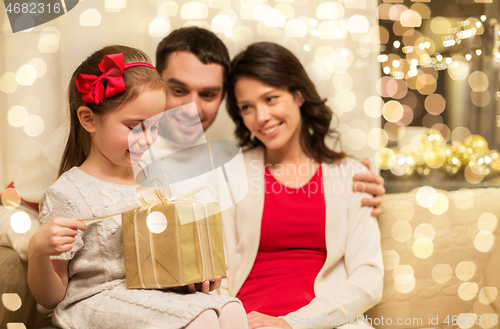 Image of happy family with christmas present at home