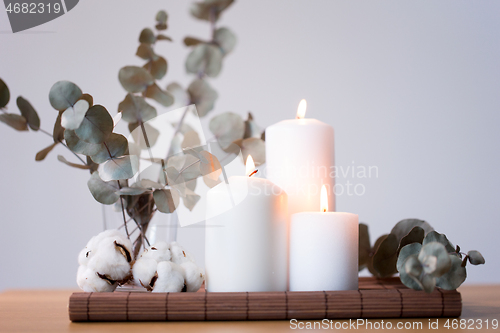 Image of candles and branches of eucalyptus on table