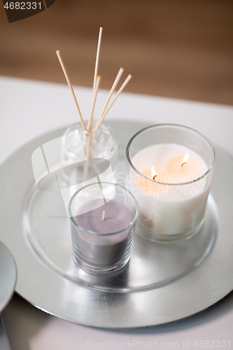 Image of aroma reed diffuser an candles burning on tray