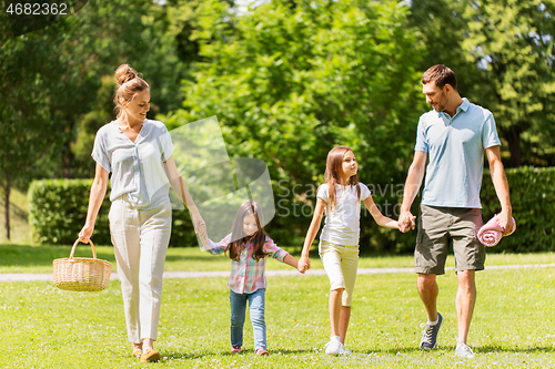 Image of family with picnic basket walking in summer park