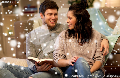 Image of happy couple reading book at home