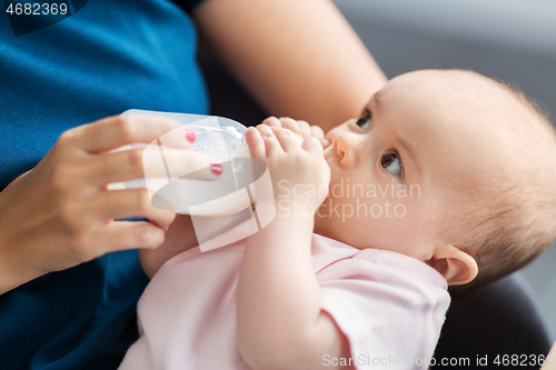 Image of close up of mother feeding baby with milk formula