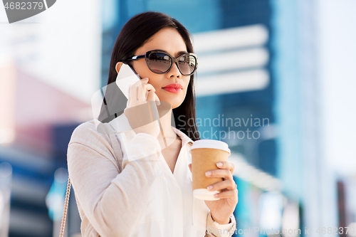 Image of asian woman calling on smartphone in city