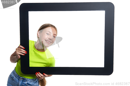 Image of Teen girl peeking through digital tablet frame