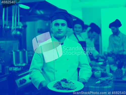 Image of Chef holding dish of fried Salmon fish fillet