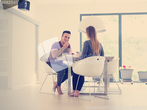 Image of couple enjoying morning coffee and strawberries