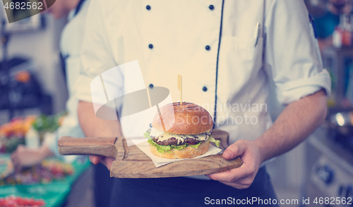 Image of chef finishing burger