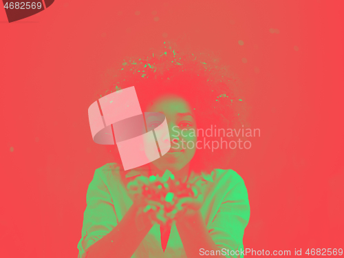 Image of black woman blowing confetti in the air