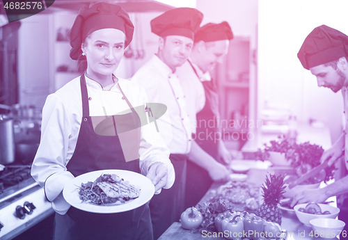 Image of Chef holding dish of fried Salmon fish fillet