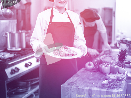 Image of Chef holding dish of fried Salmon fish fillet