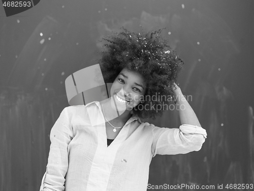 Image of black woman blowing confetti in the air