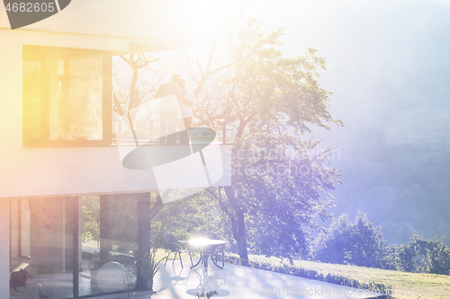 Image of couple enjoying morning coffee on balcony