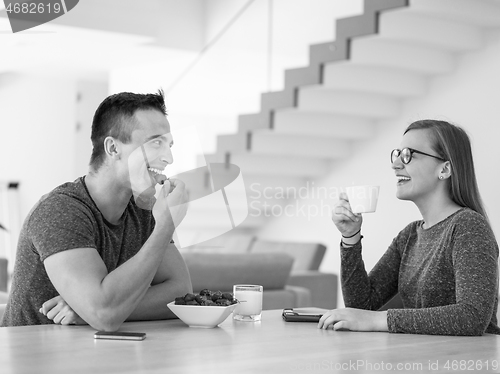 Image of couple enjoying morning coffee and strawberries