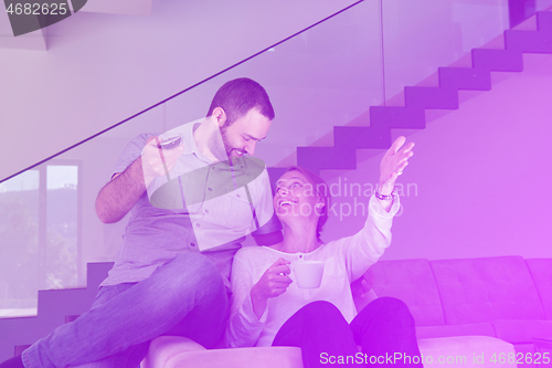 Image of romantic couple on the sofa watching television