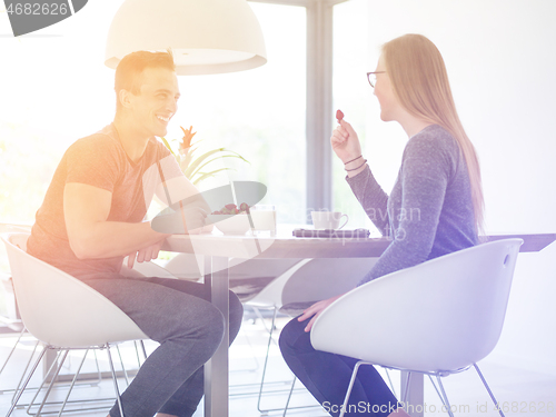 Image of couple enjoying morning coffee and strawberries