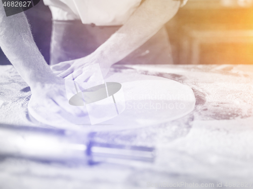 Image of chef preparing dough for pizza