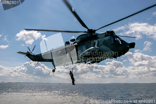 Image of NATO rescue mission in sea with helicopter.