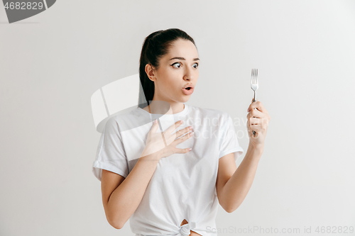 Image of Young fun crazy brunette housewife with fork isolated on white background