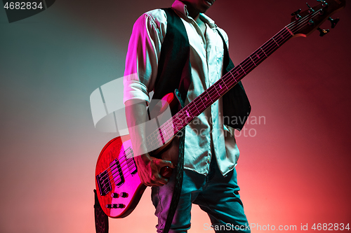 Image of African American jazz musician holding bass guitar.