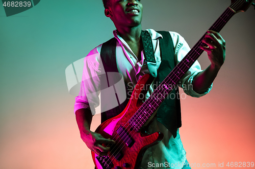 Image of African American jazz musician playing bass guitar.