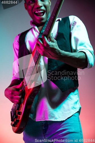 Image of African American jazz musician playing bass guitar.