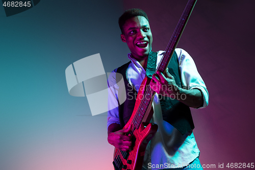 Image of African American jazz musician playing bass guitar.