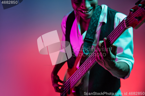 Image of African American jazz musician playing bass guitar.