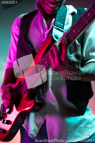 Image of African American jazz musician playing bass guitar.