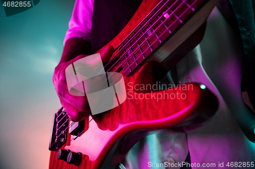 Image of African American jazz musician playing bass guitar.