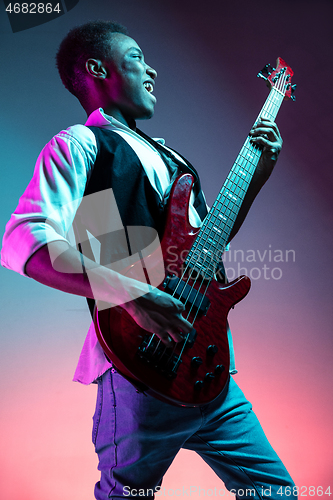 Image of African American jazz musician playing bass guitar.