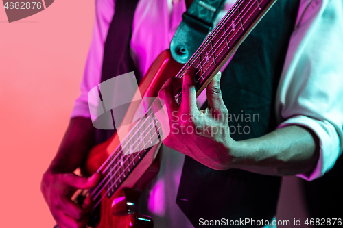 Image of African American jazz musician playing bass guitar.