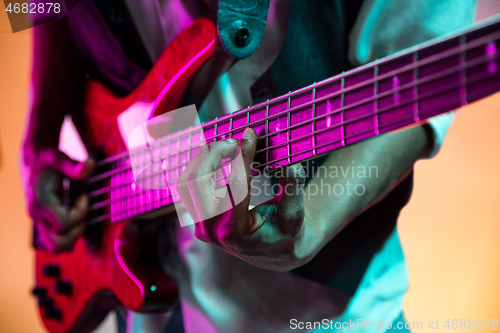 Image of African American jazz musician playing bass guitar.