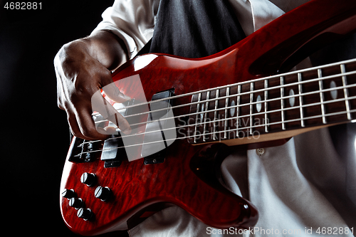 Image of African American jazz musician playing bass guitar.