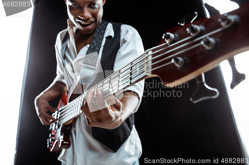 Image of African American jazz musician playing bass guitar.