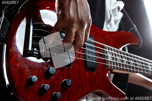 Image of African American jazz musician playing bass guitar.