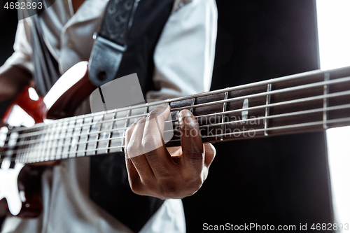 Image of African American jazz musician playing bass guitar.